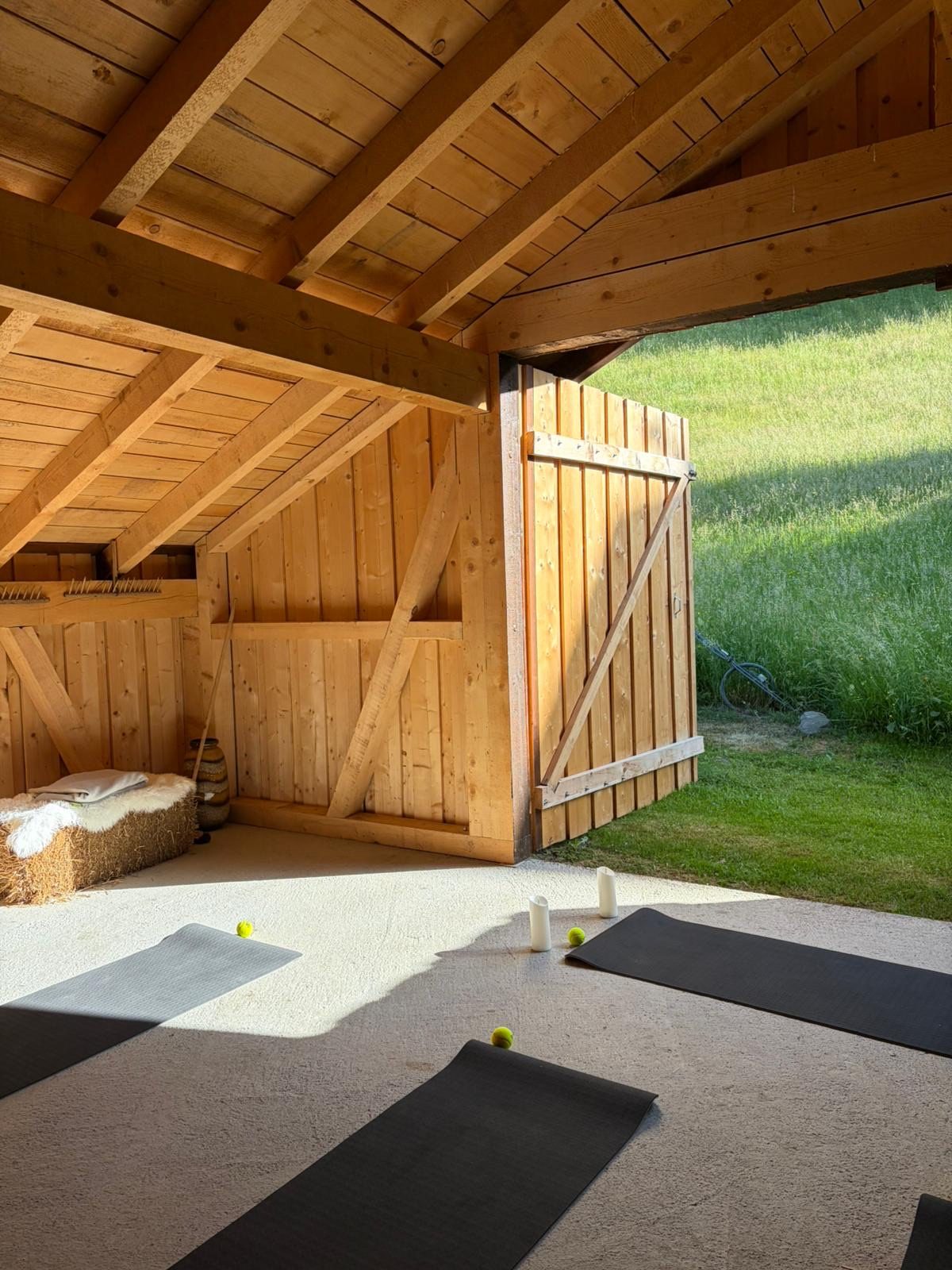 The open yoga barn with mats and mountain view